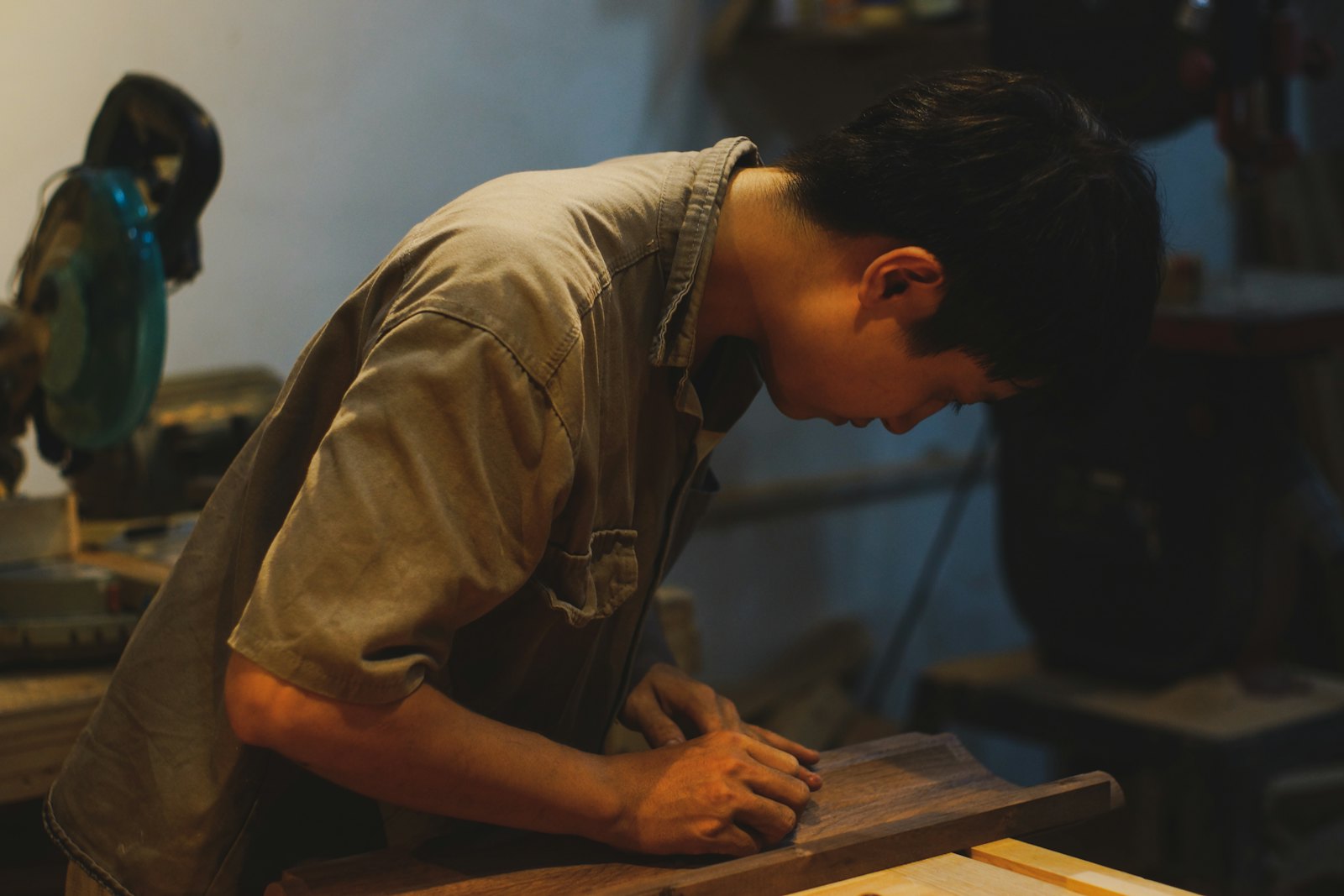 工房で木の板を研磨する職人